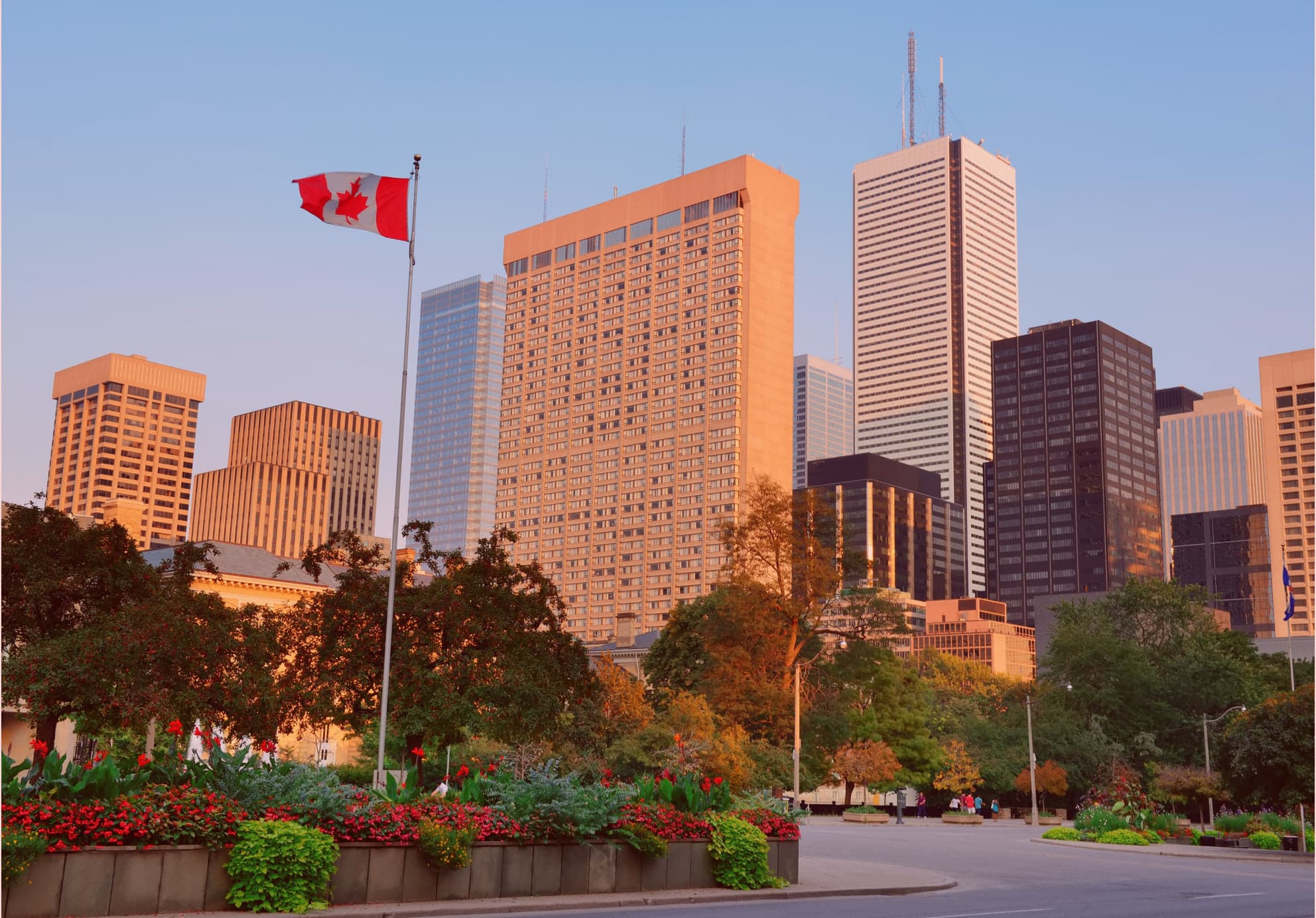 Canadian flag flying in front of the Toronto skyline