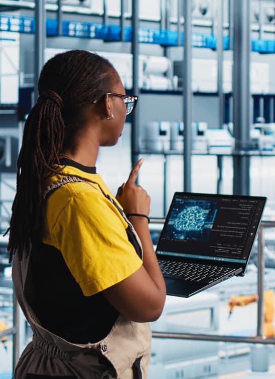 Engineer holding a laptop inside a high-tech facility
