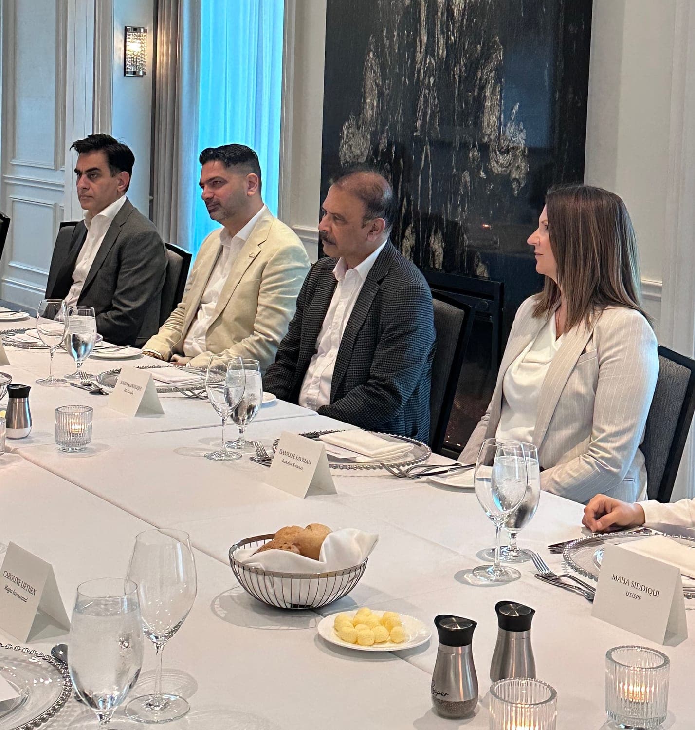 Participants seated at the table listening during the Executive Roundtable